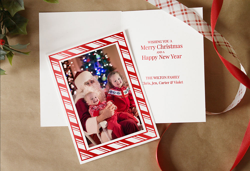 Christmas photo insert card with peppermint candy design frames a picture with Santa