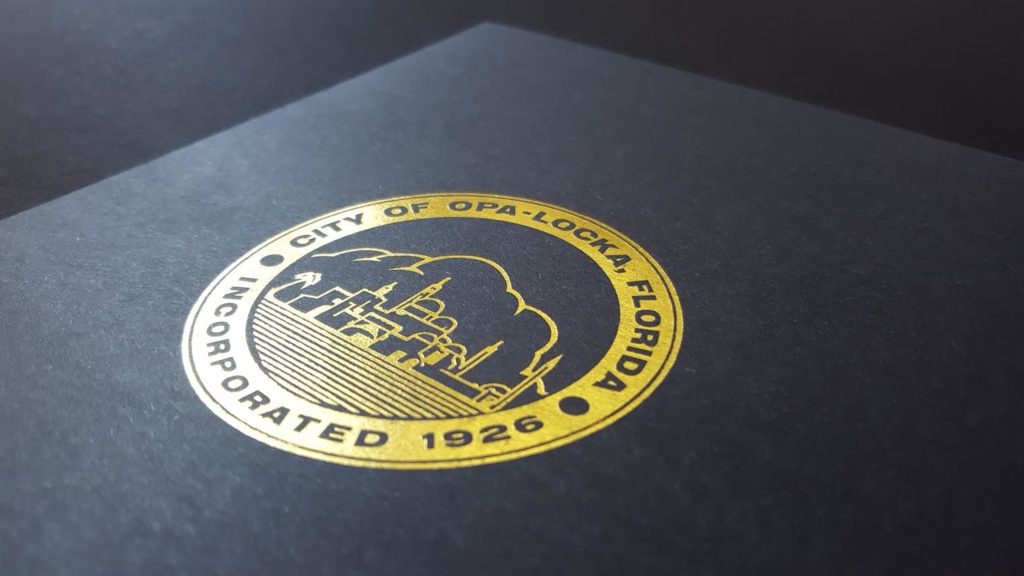 Gold foil city logo on smooth black photo folder