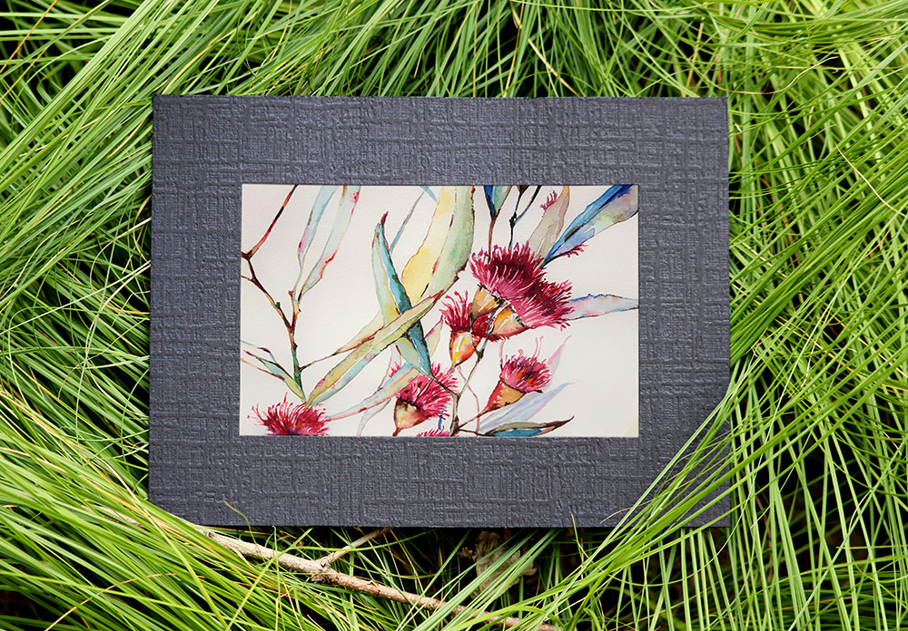Textured black paper frame with watercolor painting, set on long, flowing Prairie Dropseed grass blades.