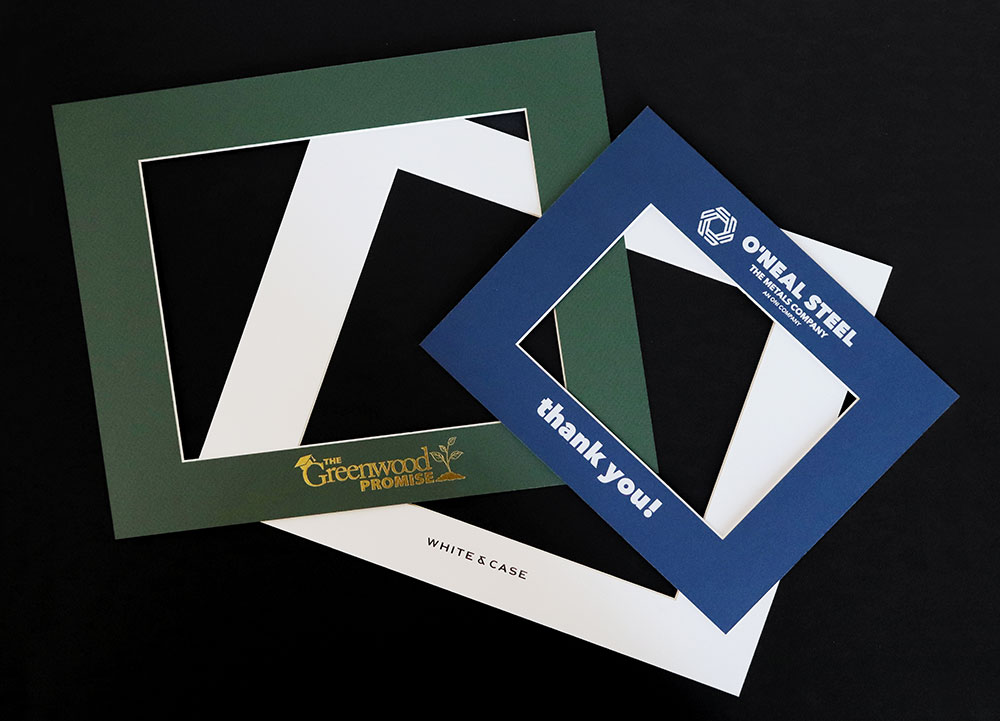 Green, white, and blue photo mats imprinted with company logos.
