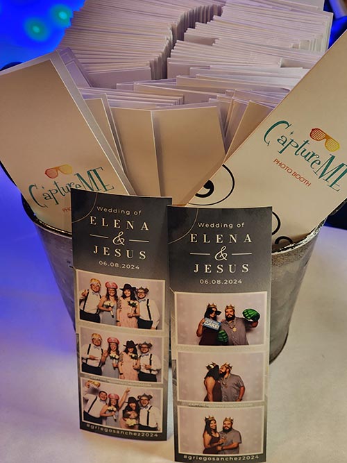 A collection of photo folders stacked in a metal bucket with picture strips in front.